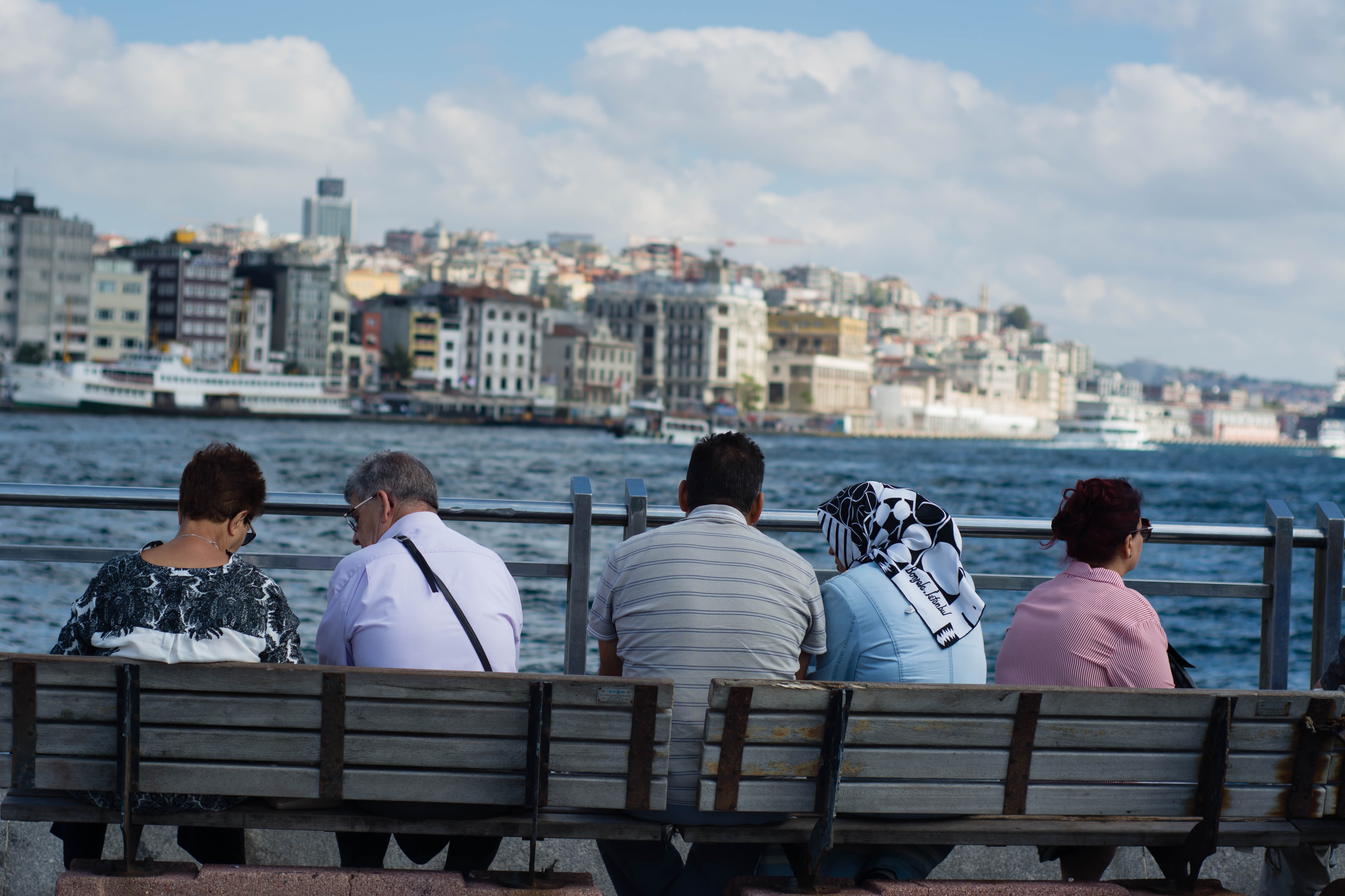 Men and women sit together on a bench in Istanbul, Turkey.