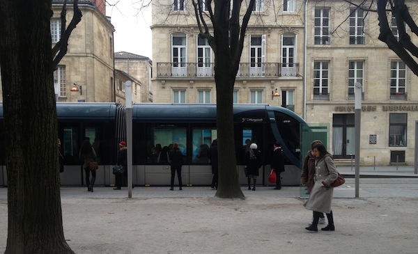 A tram arriving at a stop in Bordeaux, France.